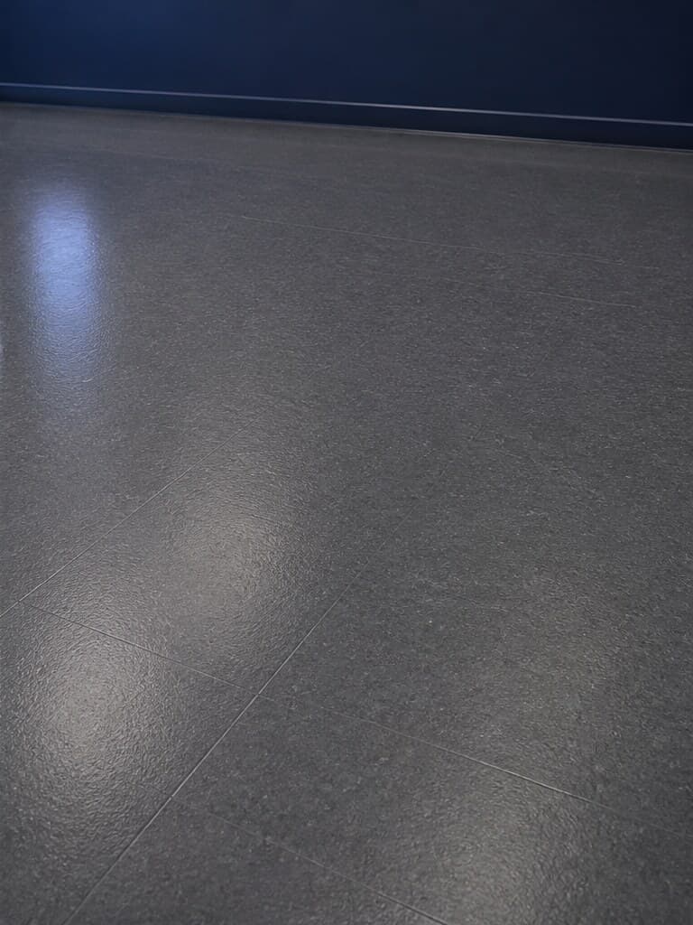 Illustrative close view of a graphite resilient floor with a satin sheen.